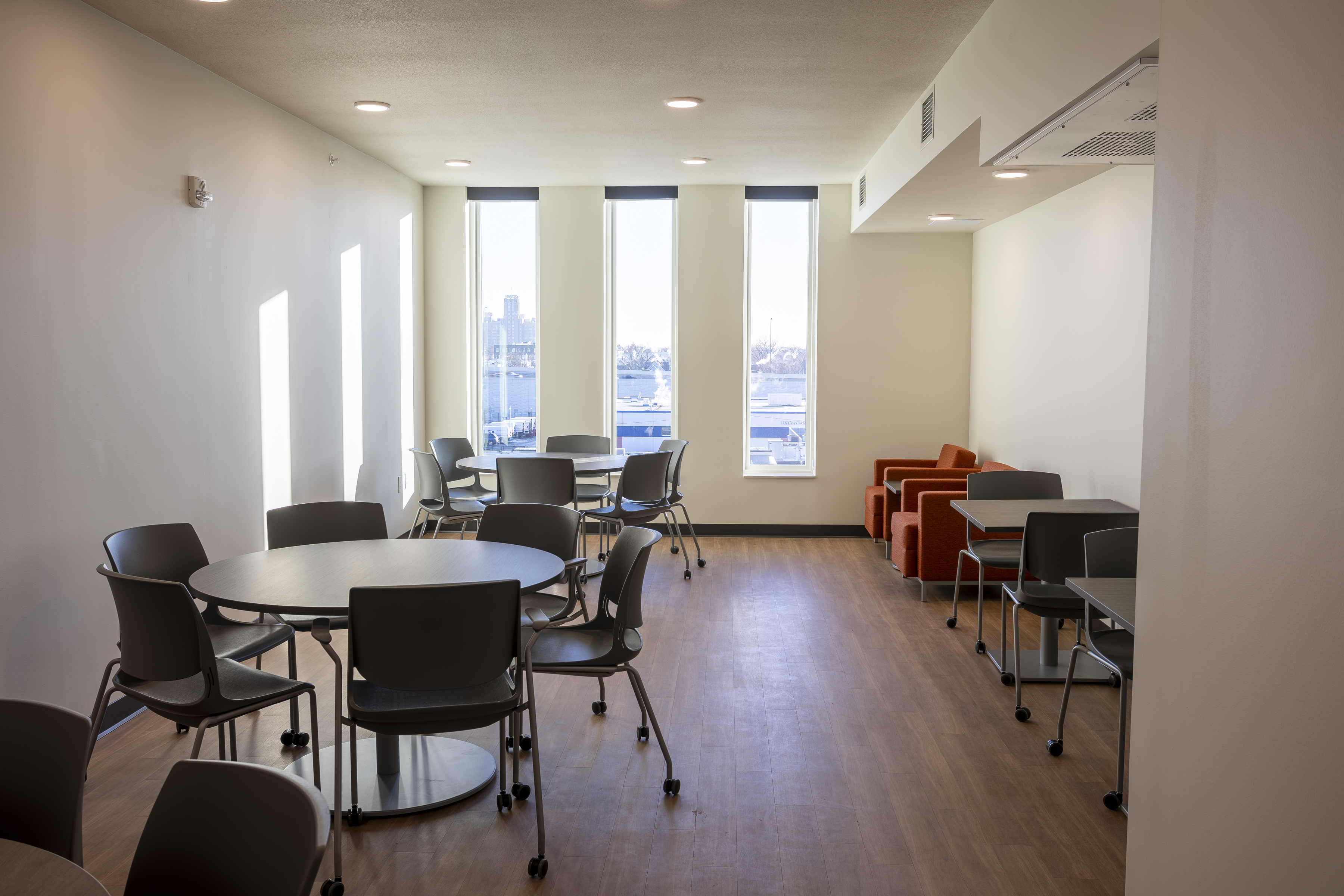 plenty of chairs and tables located in community room as a place to gather