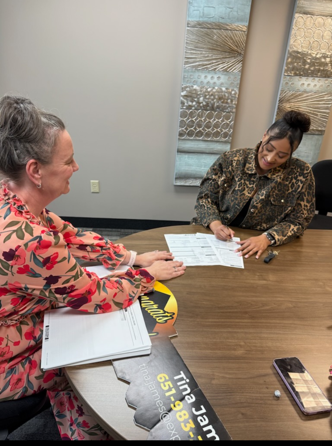 Two women signing financial papers