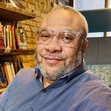 Man with glasses sitting and smiling