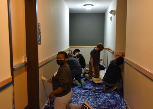 Students painting apartment hallway