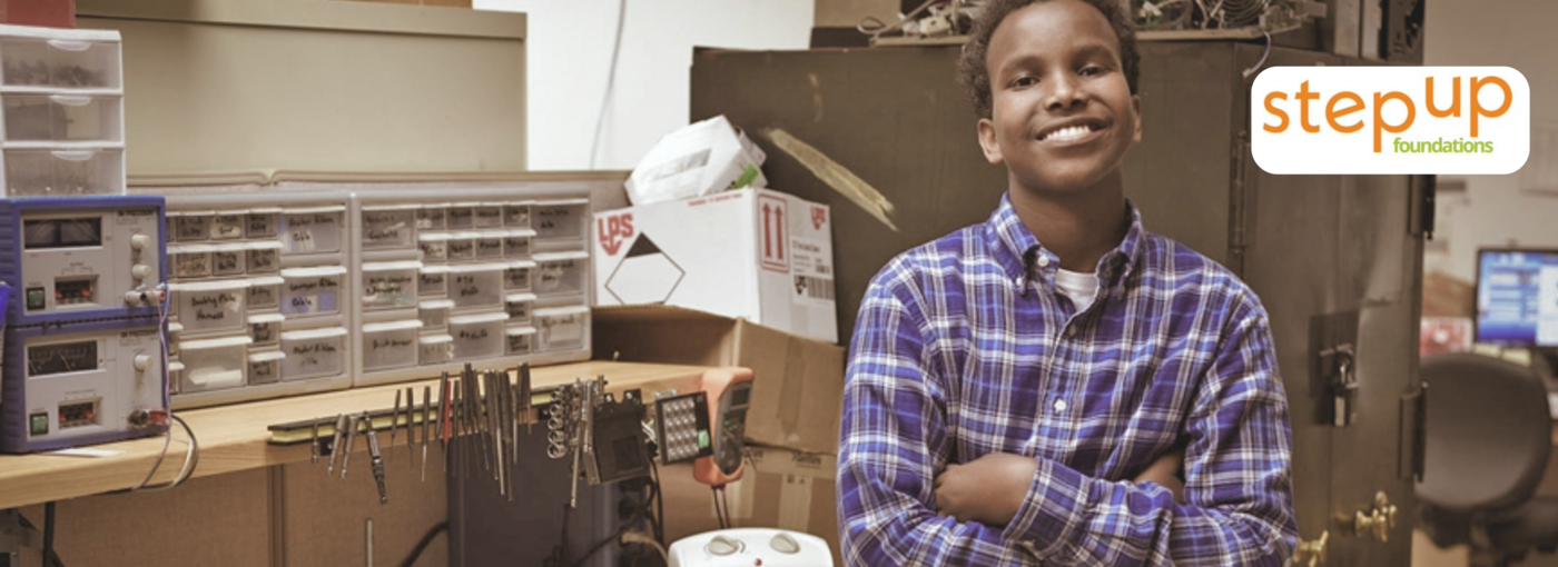 Young man standing in workshop smiling