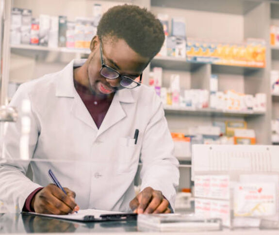 Male pharmacy tech behind counter