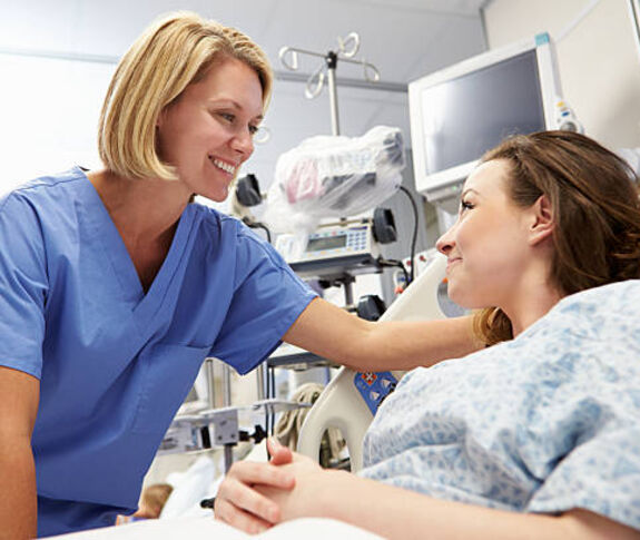 Female staff smiling at female hospital patient