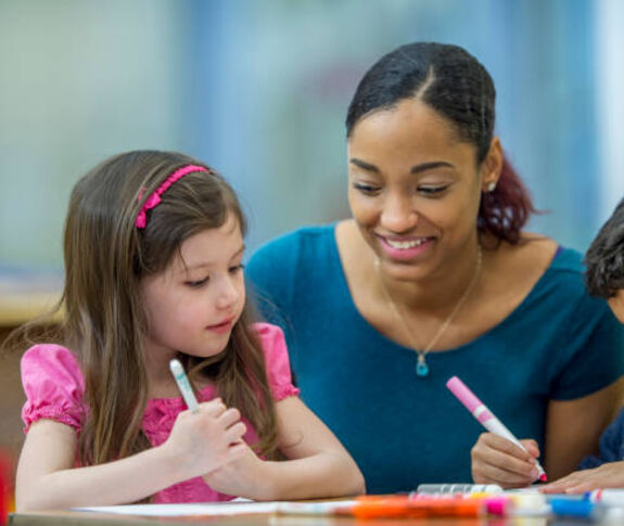 woman helping kids in classroom