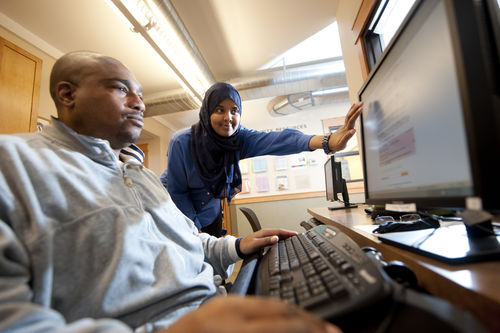 Women and man look at computer screen