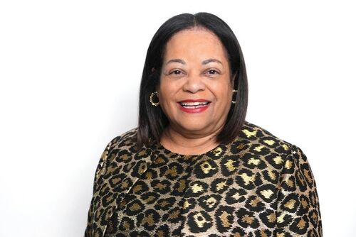Karla Henderson smiling in a metallic print top