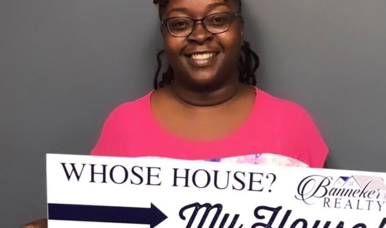 women smiling holding sign