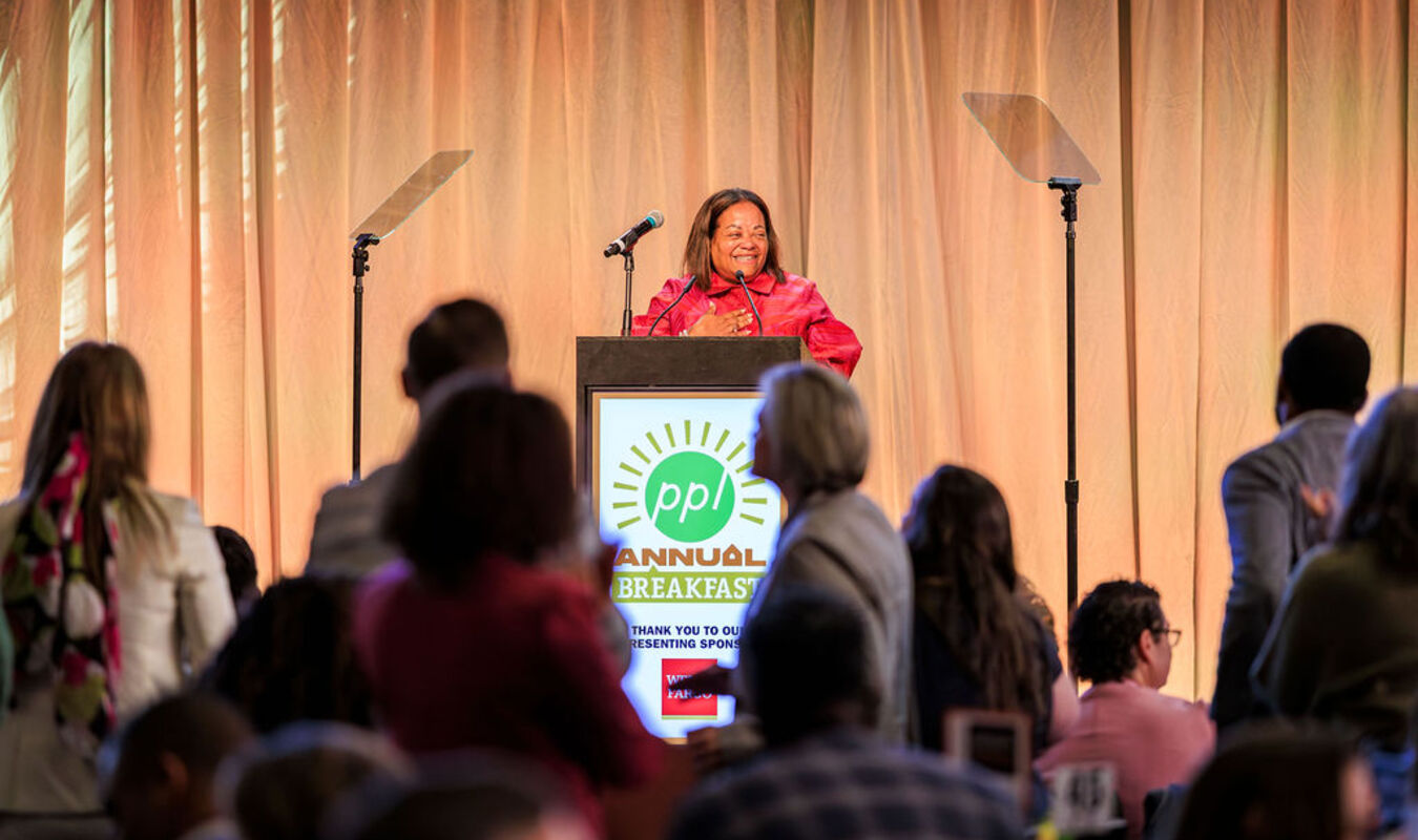Karla speaking at podium at Breakfast