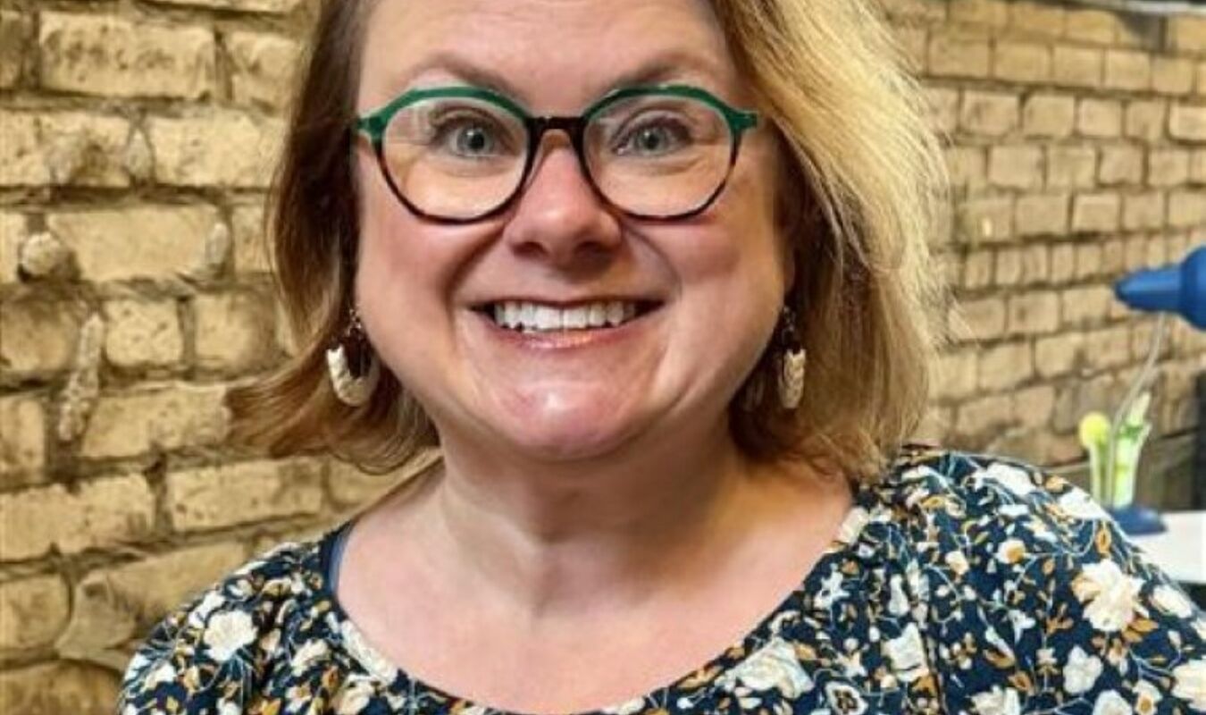 woman in glasses with floral top smiling