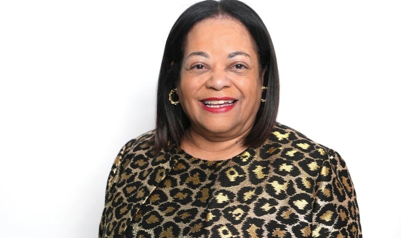 Karla Henderson smiling in a metallic print top