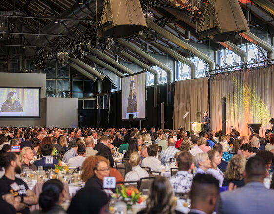 Huge room with a thousand people listening to a speaker on stage